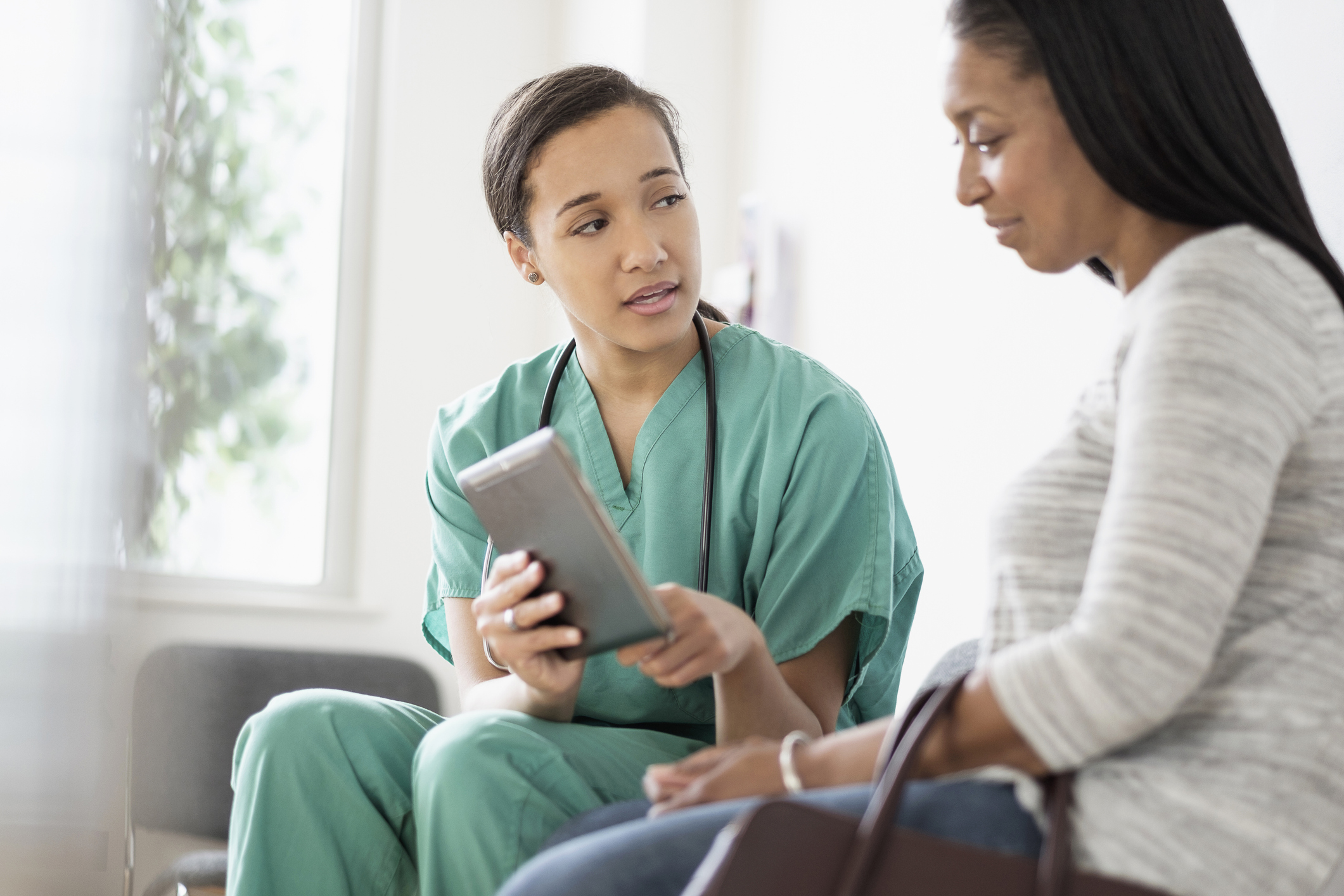 nurse sitting down talking with patient