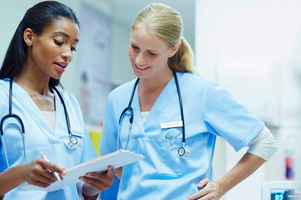 two nurses looking at clipboard